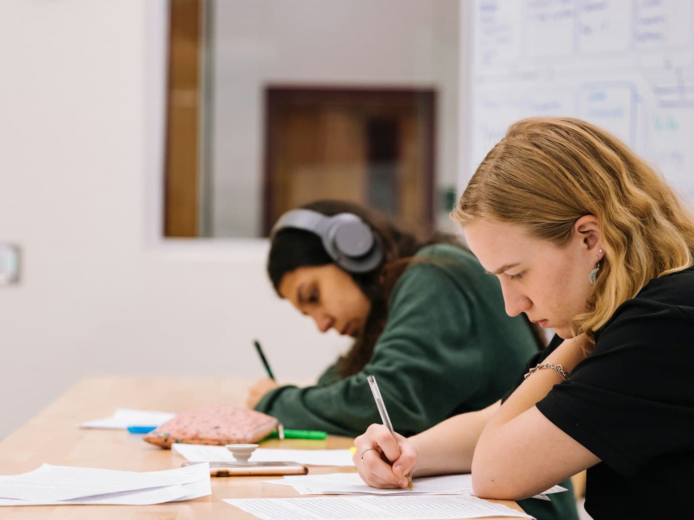 Two students working through exam questions side by side